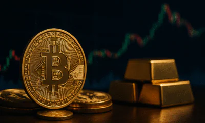 Immagine fotorealistica di tre token Bitcoin dorati in primo piano, con lingotti d'oro e un grafico a candele sfocato sullo sfondo, a simboleggiare la scarsità di Bitcoin e i mercati finanziari.
