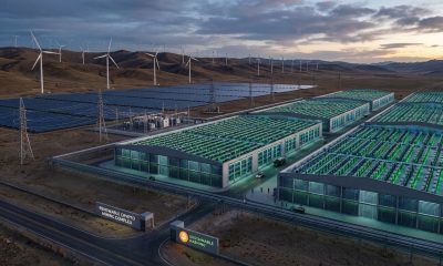 A large Bitcoin mining facility powered by wind turbines, solar panels, and high-voltage transmission lines, with thousands of ASIC mining rigs illustrating how cleaner energy can support expanding Bitcoin mining activity rather than reducing its overall environmental footprint.