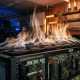 Close-up of cryptocurrency mining servers emitting visible heat that transitions into glowing heating pipes, illustrating waste heat recovery and intelligent energy management in smart buildings.
