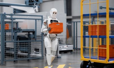 Apptronik Apollo humanoid robot carrying an industrial tote in a manufacturing facility